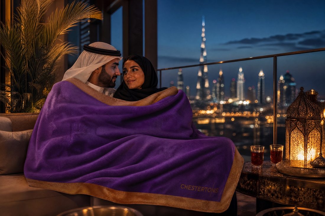 Couple wrapped in the blanket on a lantern-lit terrace with the skyline behind